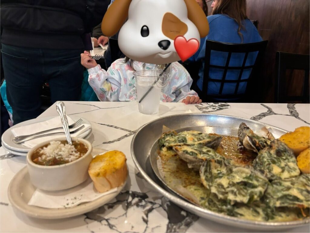 子どもが座るテーブルに並べられた焼き牡蠣料理とガンボスープ。