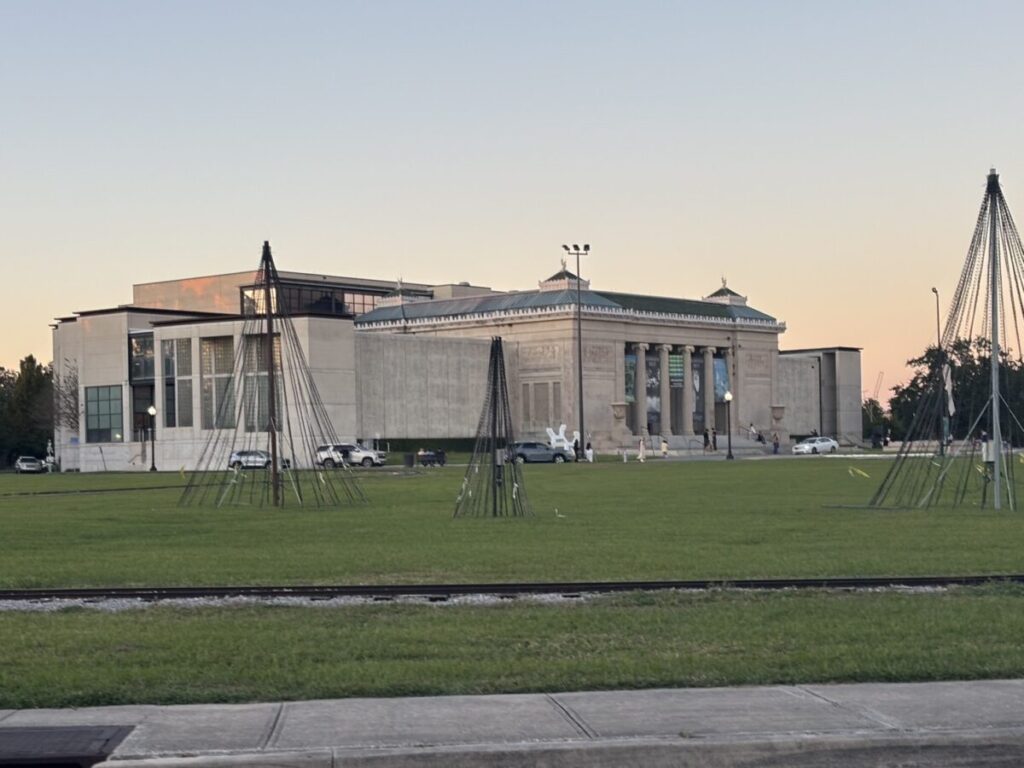 夕暮れ時の芝生広場越しに見えるニューオーリンズ美術館(NOMA)の外観。