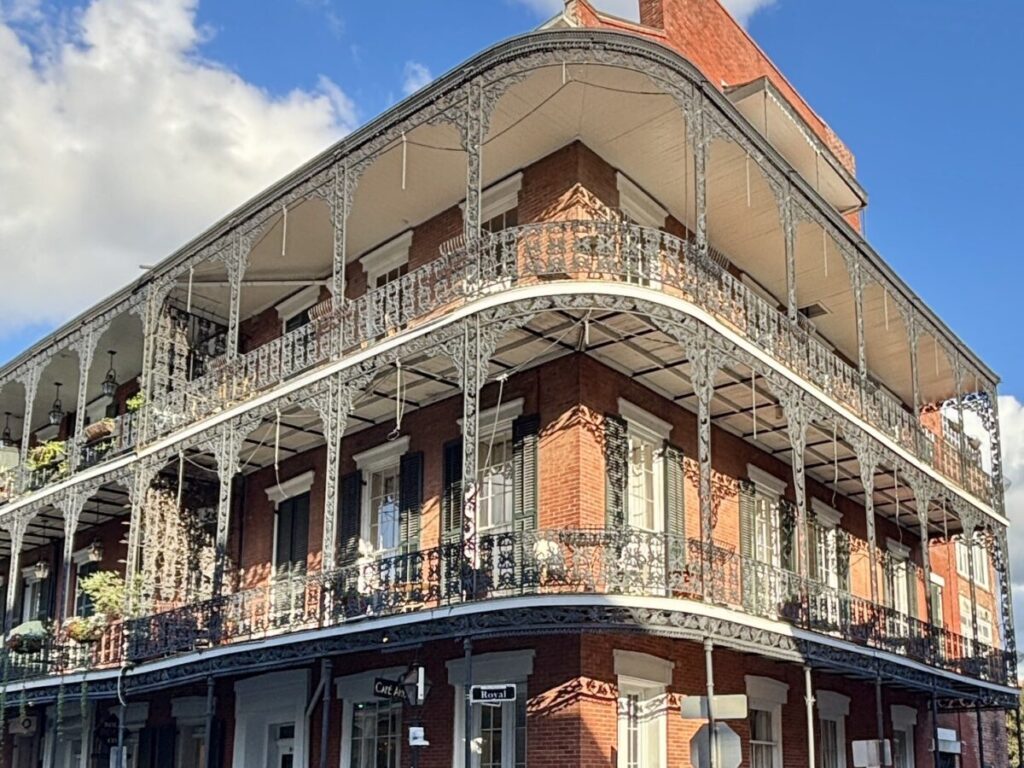ニューオーリンズのフレンチクォーターにある赤レンガの建物と、繊細なアイアンバルコニー装飾。