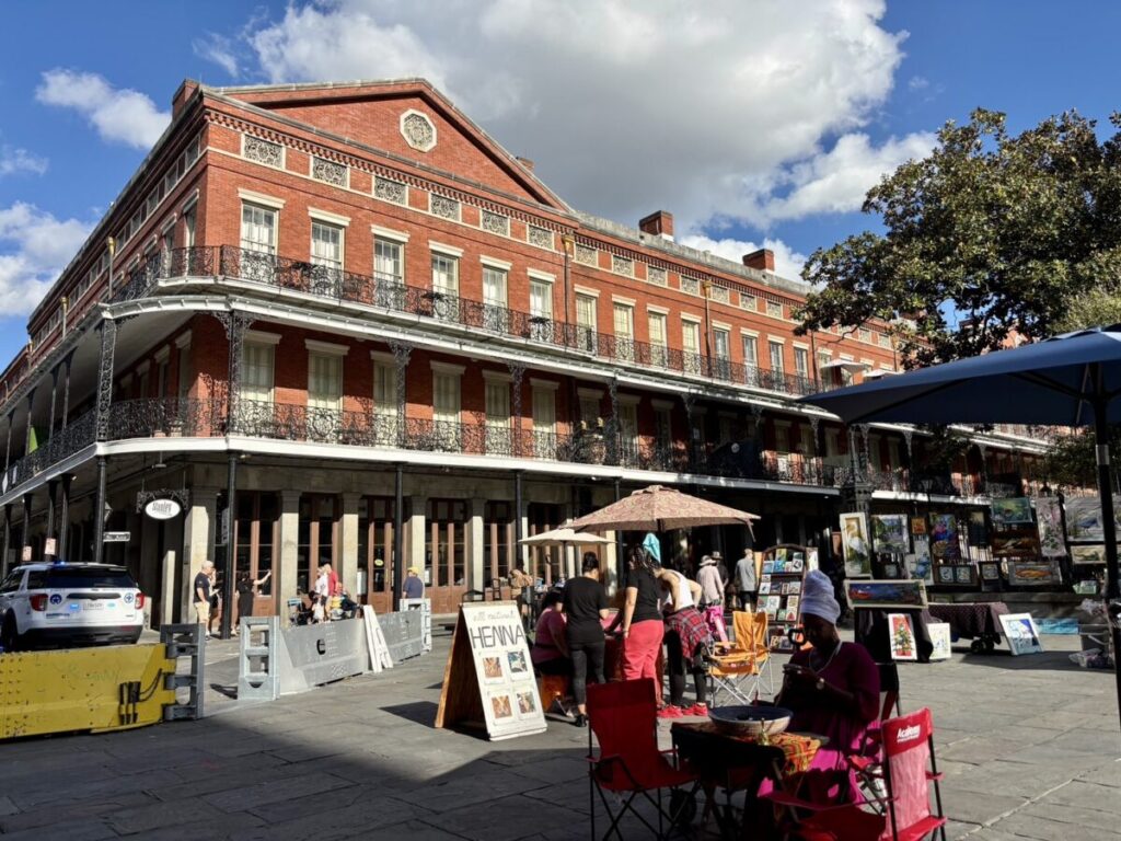 ニューオーリンズのフレンチクォーターに並ぶ赤レンガの建物とアートマーケットの風景。