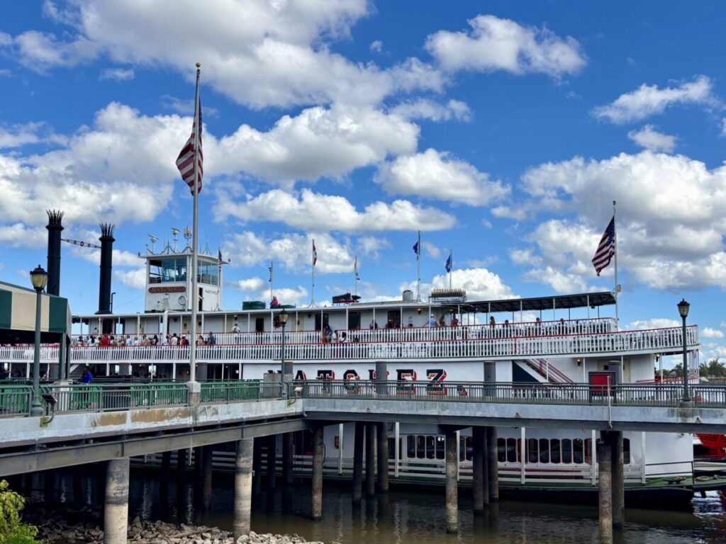 ミシシッピ川に停泊する蒸気船ナチェズ号の外観と乗船客の様子。