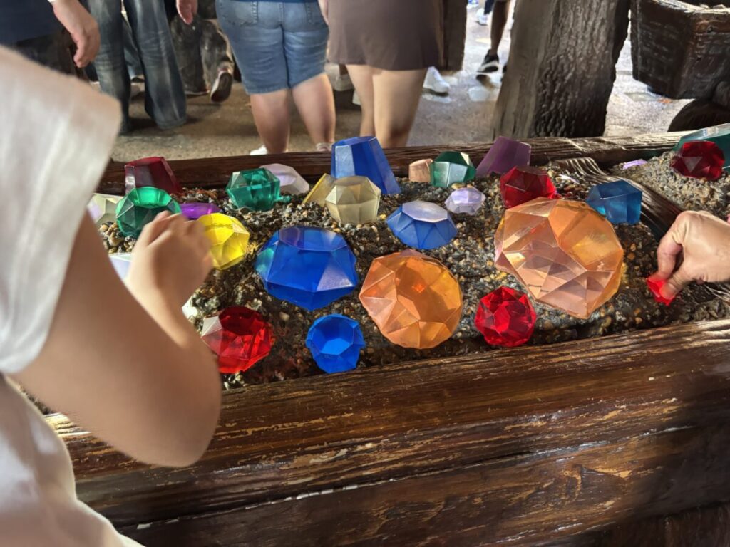 7人のこびとのマイントレイン待ち列で宝石に触れて遊ぶ子ども