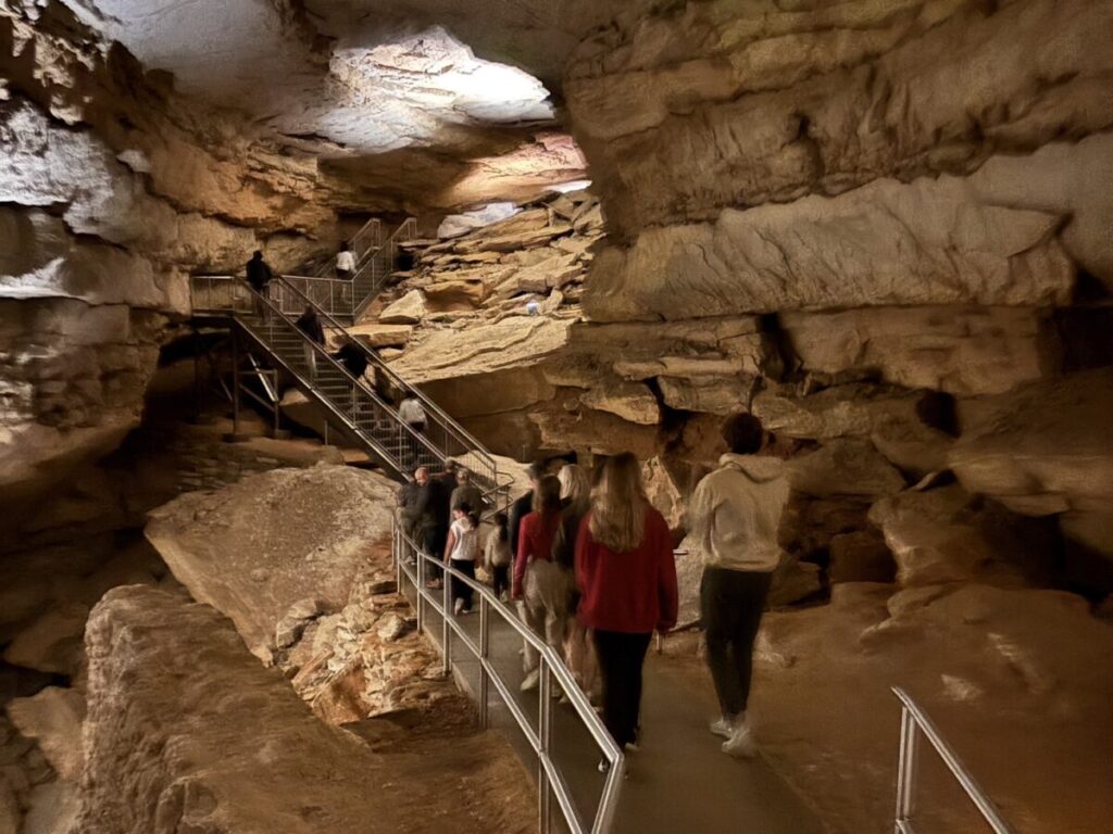マンモスケーブ国立公園の洞窟内を歩く参加者と巨大な岩壁