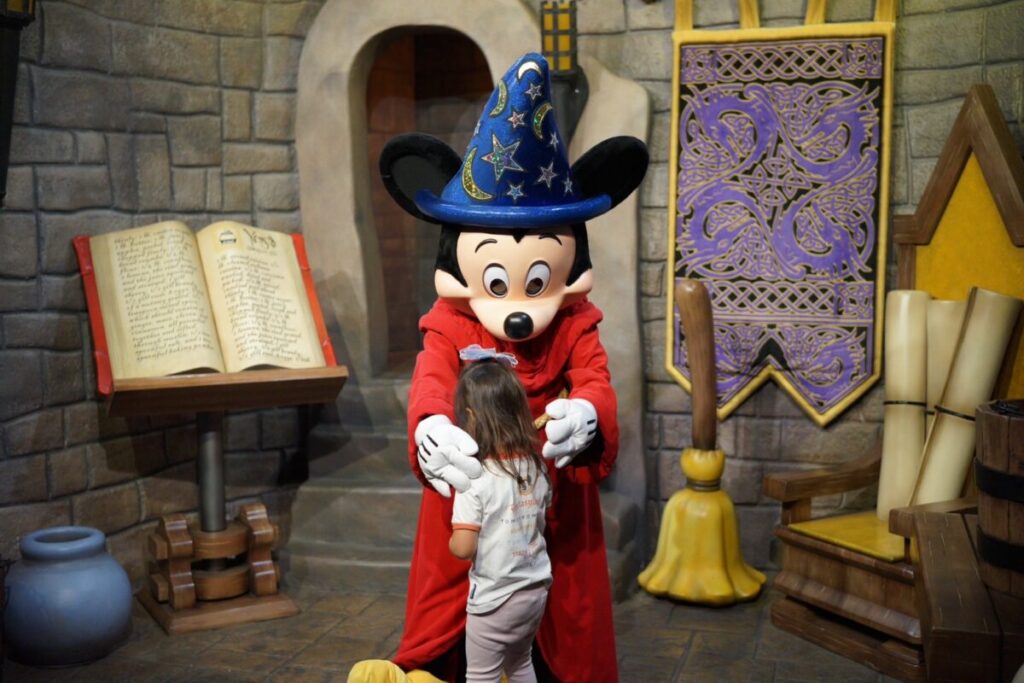 魔法使いの弟子衣装のミッキーマウスと子どものグリーティング