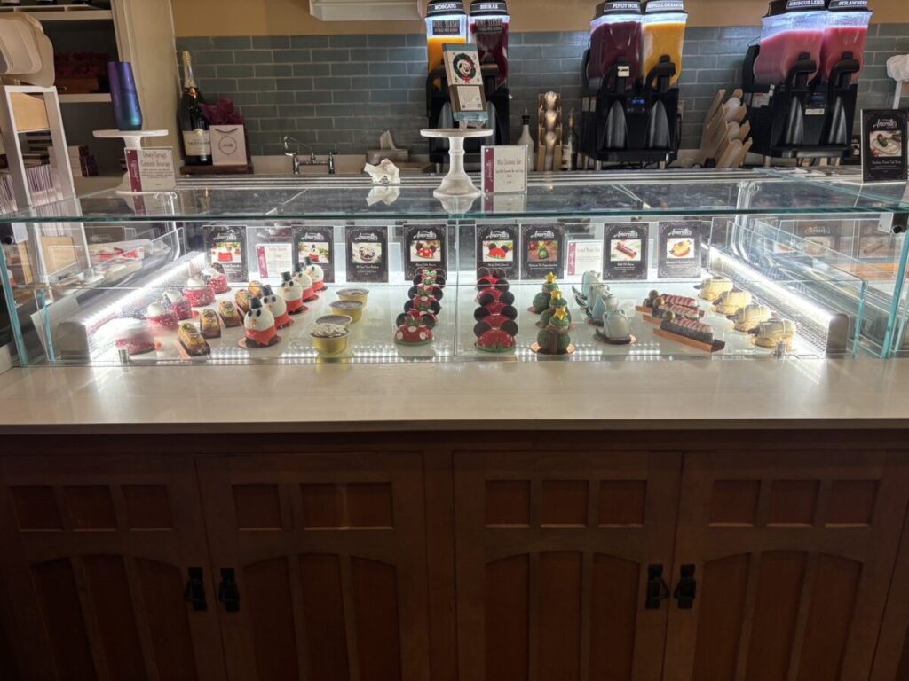 ミッキーの耳が付いた赤いドーム型ケーキがショーケースに並ぶ様子