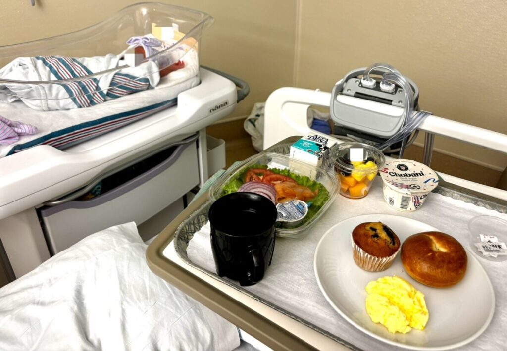 母子同室の病室で新生児のベッドの横に置かれた朝食